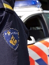 Agent met politieauto op achtergrond